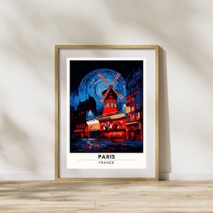 May include: A framed poster with a colorful illustration of a red windmill building in Paris, France. The building is lit up at night and has a blue sky with stars in the background. The text "PARIS FRANCE" is at the bottom of the poster.