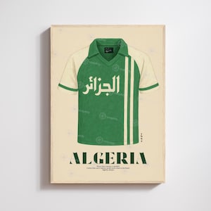 Peut inclure: Impression encadrée d'un maillot de football vert et blanc avec le mot "ALGERIA" en gras en bas. Le maillot porte le mot "الجزائر" en écriture arabe. L'impression a un fond de couleur crème.