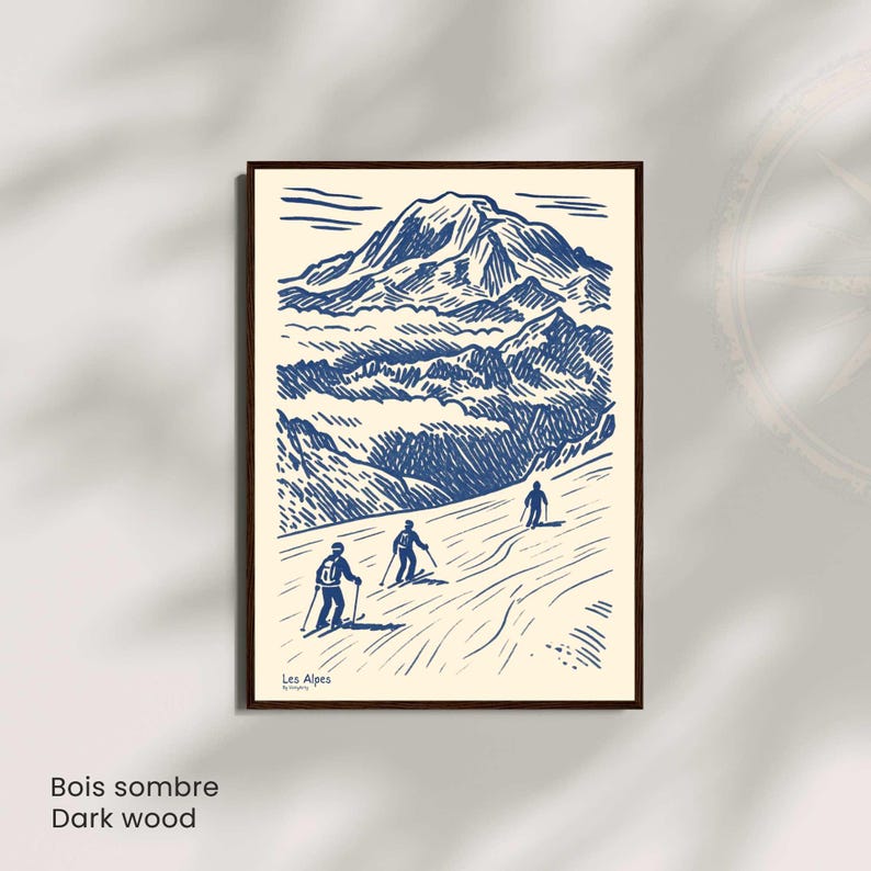 May include: A framed print with a blue and white illustration of a mountain range and skiers. The artwork includes the text "Les Alpes" and "Dark wood". The print is in a dark wood frame.