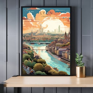 May include: A framed art print showing a stylized illustration of Lyon, France. The artwork depicts a cityscape with a river, bridges, and buildings under a sunset sky. The text "LYON FRANCE" is at the top.