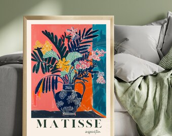 May include: A framed art print featuring a vibrant still life in the style of Matisse. The artwork showcases a blue vase filled with colorful flowers against a backdrop of coral, teal, and orange. The print includes the text "MATISSE inspiration."