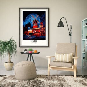 May include: A framed poster with a colorful illustration of a windmill in Paris, France. The poster has the text "PARIS" and "FRANCE" printed below the image.