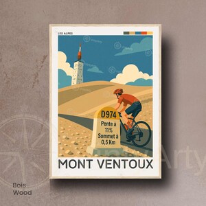 K&ouml;nnte beinhalten: Ein gerahmter Kunstdruck mit einem Radfahrer, der den Mont Ventoux hinauff&auml;hrt. Das Kunstwerk im Stil eines Vintage-Reiseposters zeigt einen Radfahrer auf einem Rennrad, einen Turm und den Text "MONT VENTOUX". Der Druck enth&auml;lt den Text "LES ALPES" und "D974 Pente &agrave; 11% Sommet &agrave; 0,5 Km".