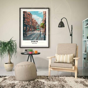 May include: A framed art print showing a street scene in Dublin, Ireland. The artwork features a green tram on a cobbled street, flanked by buildings. The print has a white border and the word "DUBLIN" is printed at the bottom.