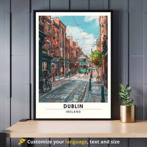 May include: A framed art print showing a street scene in Dublin. The image features a green tram on a cobbled street, flanked by brick buildings. The sky is blue with clouds. The print is labelled "DUBLIN IRELAND" at the bottom.