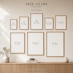 May include: A size guide chart titled VINTY ARTY displaying nine rectangular frames in various sizes, labeled with dimensions in both centimeters and inches, ranging from A4 to 60 by 90 cm, arranged on a wall above a wooden surface.
