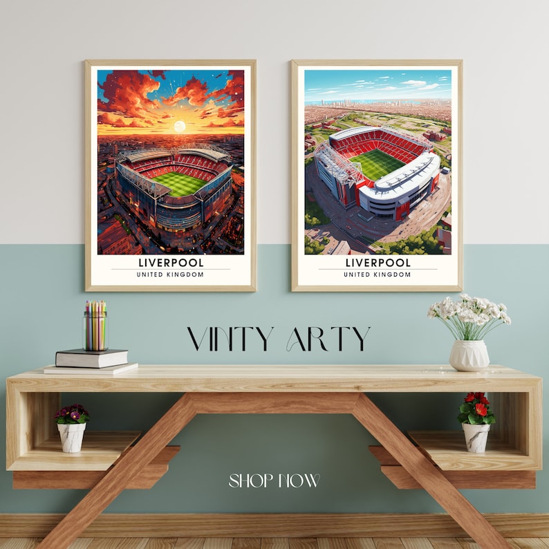 May include: Two framed prints of an aerial view of a soccer stadium in Liverpool, England. The prints are on a wooden table with a vase of flowers and a potted plant. The text on the prints reads "Liverpool, United Kingdom".