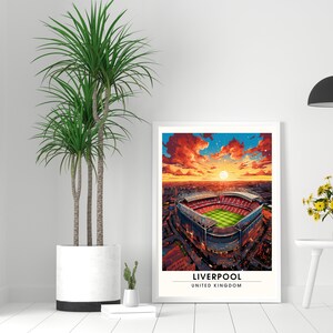 May include: A digital painting of Anfield Stadium in Liverpool, England. The stadium is shown from an aerial view, with the pitch and stands visible. The sky is a vibrant orange and red, with clouds and stars. The text "LIVERPOOL" and "UNITED KINGDOM" is at the bottom of the image.