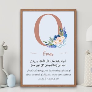 May include: A framed art print featuring a large, coral-colored letter "O" adorned with watercolor flowers in blue, pink, and green. The name "Omar" is written below the letter, with text in Arabic and French. The artwork is in a wooden frame.
