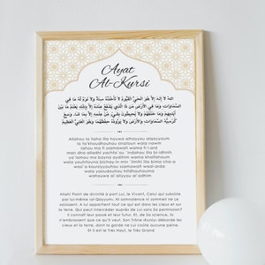 以下が含まれることがあります： 金色の模様の縁取りが施された白い額縁に入ったプリント。プリントには、コーランの一節であるアヤット・アル・クルシーのアラビア語のテキストと、その下に英語訳が書かれている。テキストは白い背景に黒いフォントで書かれている。