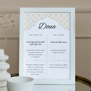 Könnte beinhalten: Ein weißer gerahmter Druck mit einem gold-weißen geometrischen Muster. Der Druck zeigt das Wort "Doua" in großer Schrift und den arabischen Text für die Morgen- und Abendgebete. Der Text ist unter dem arabischen Text ins Englische übersetzt.