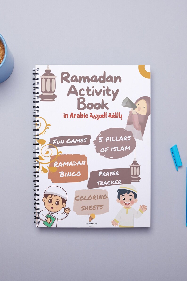 Może przedstawiać: Biała książka z ćwiczeniami z kolorową okładką przedstawiającą ilustracje dzieci i zajęć związanych z Ramadanem. Tytuł to "Ramadan Activity Book" w języku angielskim i arabskim. Książka zawiera takie zajęcia jak: gry, 5 filar&oacute;w islamu, bingo ramadanu, śledzenie modlitw i kolorowanki.