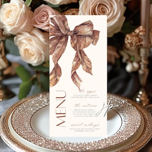May include: A menu card with a watercolor illustration of a brown bow and leaves. The menu lists appetizers, entrees, and sweet endings. The card is on a decorative plate with a floral background.