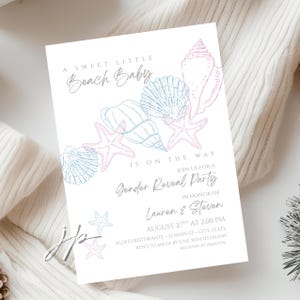 Könnte beinhalten: Eine weiße Einladungskarte mit Strandmotiv. Der Text lautet "A Sweet Little Beach Baby Is On The Way" mit Illustrationen von Muscheln und Seesternen in Blau und Rosa. Die Karte ist für eine Gender-Reveal-Party.
