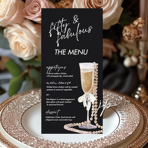 May include: A black menu card with the text "Fifty & Fabulous" and "THE MENU" in white script. The menu lists appetizers, main course, and dessert options. A champagne glass with a pearl necklace is on the right.
