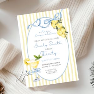 May include: A birthday party invitation with a watercolor design. The invitation features a yellow and white striped background, a blue oval frame, and a watercolor illustration of lemons and a cocktail. The text reads "a tiny drop older" and "Turning Thirty".