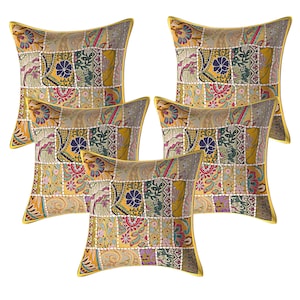 May include: Set of five yellow throw pillows with a patchwork design featuring various floral patterns in shades of pink, purple, green, and blue.