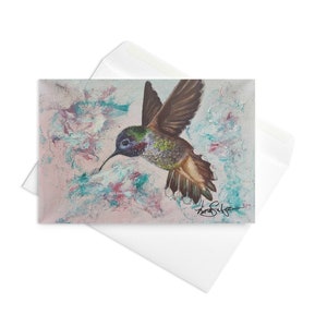 Kolibri - Affirmationskarte mit einem Kolibri im Flug vor einem rosa und grünen Hintergrund