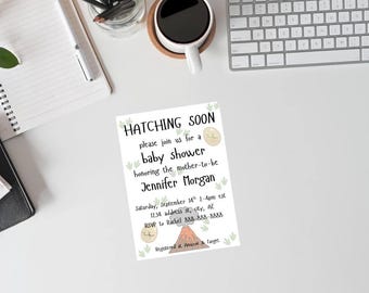 May include: A baby shower invitation with the text "HATCHING SOON" and details for Jennifer Morgan's baby shower. The invitation features dinosaur and volcano illustrations, with a white background.