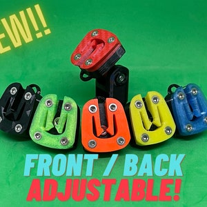 Op de afbeelding: Een verzameling kleurrijke, verstelbare apparaten in zwart, groen, oranje, geel en blauw. De apparaten hebben een U-vormig ontwerp met zilveren hardware. Het woord "NEW!!" staat in gele tekst en "FRONT / BACK ADJUSTABLE!" staat in turquoise en rode tekst.