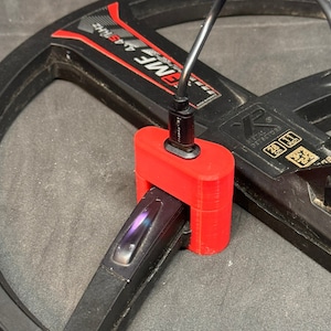 Puede incluir: Un dispositivo rojo impreso en 3D conectado a un detector de metales negro con un cable negro y un conector USB-C. El detector de metales tiene el texto "XMF 4.45kHz" y "METAL DETECTORS" impreso. El dispositivo está conectado a un dispositivo USB negro.