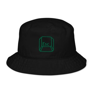 Op de afbeelding: Zwarte bucket hat met een groen geborduurd escape-toets symbool.