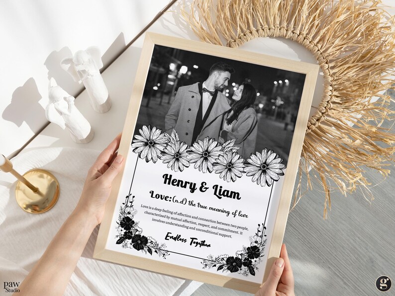 May include: A black and white photograph of a couple standing in front of a city street at night. The photo is framed with a white border and black floral designs. The text "Henry & Liam" and "Love: (n.d) the true meaning of love" is printed below the photo. The text "Endless Together" is printed below the definition of love.
