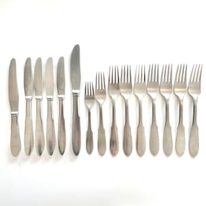 May include: A selection of stainless steel cutlery, including knives and forks, displayed on a white background. The knives have rounded blades, and the forks have four prongs. The cutlery is suitable for a formal dining occasion.