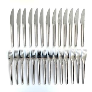 May include: A collection of stainless steel knives and forks arranged on a white surface. The knives have a sleek, modern design with a smooth, silver finish. The forks have four tines and match the knives in style.