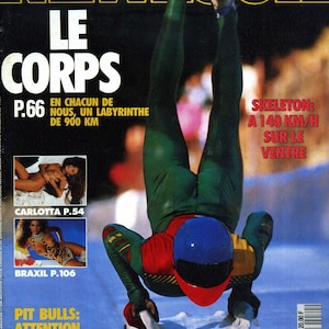 Peut inclure: Une couverture de magazine représentant un homme en combinaison de squelette verte, rouge et jaune descendant une piste sur un traîneau de squelette. Le texte de la couverture est "LE CORPS" et "SKELETON: A 140 KM/H SUR LE VENTRE".