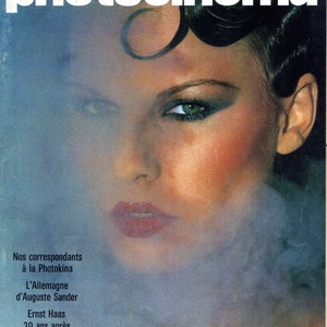 Op de afbeelding: Een tijdschriftcover met een vrouw met donker haar en dramatische oogmake-up. De titel van het tijdschrift is "le nouveau photocinéma" en de tekst onder de afbeelding luidt "Nos correspondants à la Photokina L'Allemagne d'Auguste Sander Ernst Haas 30 ans après Le NPC et le labo au Salon du bricolage MENSUEL N° 50 OCTOBRE 1976 - 6 F. SUISSE 5 FS. PUBLICATIONS PAUL MONTEL"