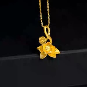 May include: A gold necklace with a pendant shaped like a lotus flower. The pendant is detailed with a stem and leaves.