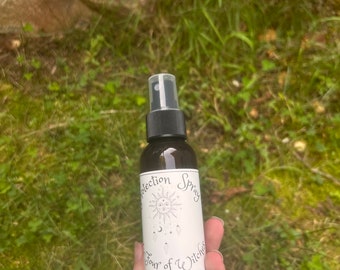 以下が含まれることがあります： 白いラベルに「Protection Spray Four of Witches」と書かれた茶色のガラス瓶。ラベルには太陽、月、ドリームキャッチャーのデザインが描かれている。