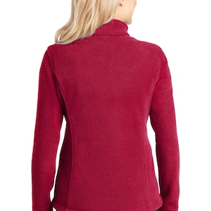May include: A red fleece jacket with a high collar and zipper closure. The jacket has long sleeves and a fitted silhouette.