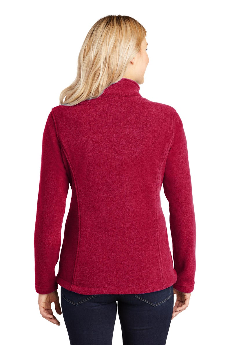 May include: A red fleece jacket with a high collar and zipper closure. The jacket has long sleeves and a fitted silhouette.
