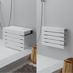 Peut inclure: Un banc de douche mural blanc au design à lattes, présenté en position horizontale étendue et en position verticale repliée contre un mur. Le produit porte la marque GARDENIA imprimée sur la surface du mur.