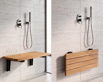 May include: A wall-mounted shower seat featuring horizontal light brown wooden slats and black metal brackets. The seat is shown in both an extended horizontal position and a folded vertical position against a light gray tiled shower wall.