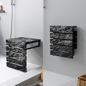 May include: A black and white marble-patterned shower bench and a matching wall-mounted towel rack. The bench has a rectangular top and slatted sides. The towel rack has a similar slatted design. Both are mounted on a light gray wall.