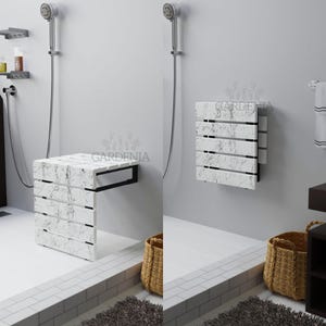 Peut inclure: Un siège de douche mural avec une surface blanche au motif marbré noir et un cadre en métal noir. Le siège est présenté en deux positions : déplié pour l'utilisation et replié à plat contre le mur. Le mot GARDENIA est visible.