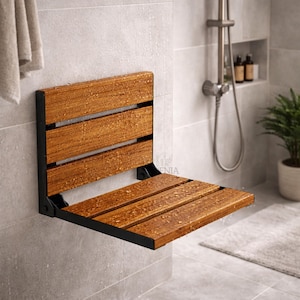 May include: A wall-mounted shower seat with a wooden seat and black metal frame. The seat is made of horizontal wooden slats. The shower seat is installed in a tiled shower with a shower head and a small plant.