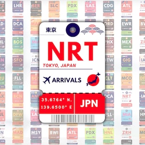 May include: A white airport arrival tag with blue and red accents. The tag is for Narita International Airport (NRT) in Tokyo, Japan. The tag includes the airport code, city, country, and coordinates. The tag also features a small red icon of Japan.