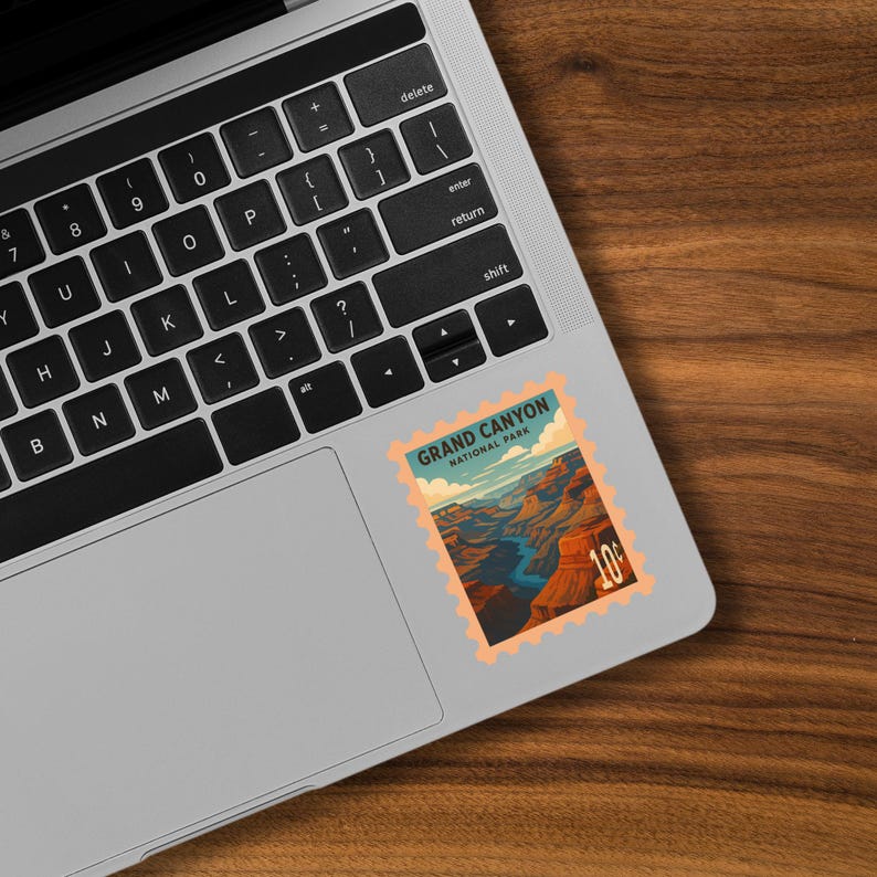 K&ouml;nnte beinhalten: Ein Aufkleber mit einer Illustration im Vintage-Stil des Grand Canyon National Park. Der Aufkleber hat ein Briefmarkendesign mit dem Text "GRAND CANYON NATIONAL PARK" und einem Wert von "10&cent;". Das Bild zeigt den Canyon mit einem blauen Fluss und orangefarbenen und braunen Felsformationen.