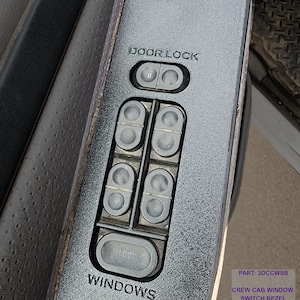 May include: Black plastic crew cab window switch bezel with the text "DOOR LOCK", "WINDOWS", and "LOCK" on the buttons. The part number "3DCCWSB" is printed on the bezel, along with the text "CREW CAB WINDOW SWITCH BEZEL" and "MADE IN THE USA".