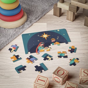 Op de afbeelding: Een kleurrijke puzzel die de kerststal voorstelt met Maria, Jozef en baby Jezus. De puzzelstukjes liggen verspreid op een houten oppervlak met een paar blokken op de voorgrond.