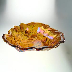 Plat en verre ambré avec détails floraux dans des tons ambrés chauds/souci