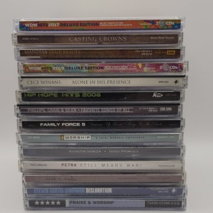 May include: A stack of 10 Christian music CDs, featuring artists like Casting Crowns, Mandisa, Cece Winans, Family Force 5, Petra, and Steven Curtis Chapman. The CDs are arranged vertically, with the titles and artist names visible. The CDs are in various shades of gray, black, and white.
