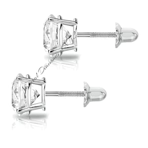 May include: A pair of silver stud earrings with a round, clear gemstone in the centre. The earrings have a screw-back fastening.