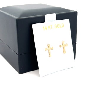 May include: A pair of gold cross earrings in a black box with a white card that says "14 KT. GOLD".