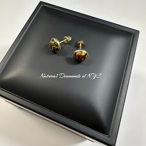 May include: A pair of gold opal stud earrings in a black jewelry box. The box has the text "Natural Diamonds of NYC" on the inside.