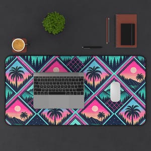 May include: A rectangular desk mat with a vibrant geometric design featuring palm trees, sunsets, and mountains in shades of pink, teal, and navy. A laptop, mouse, and other office supplies are on the mat.